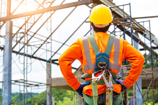 construction worker with safety harness on overlooking job site