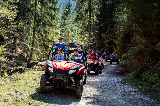 image of ATVs and UTVs in line driving along an off-road trail in the woods
