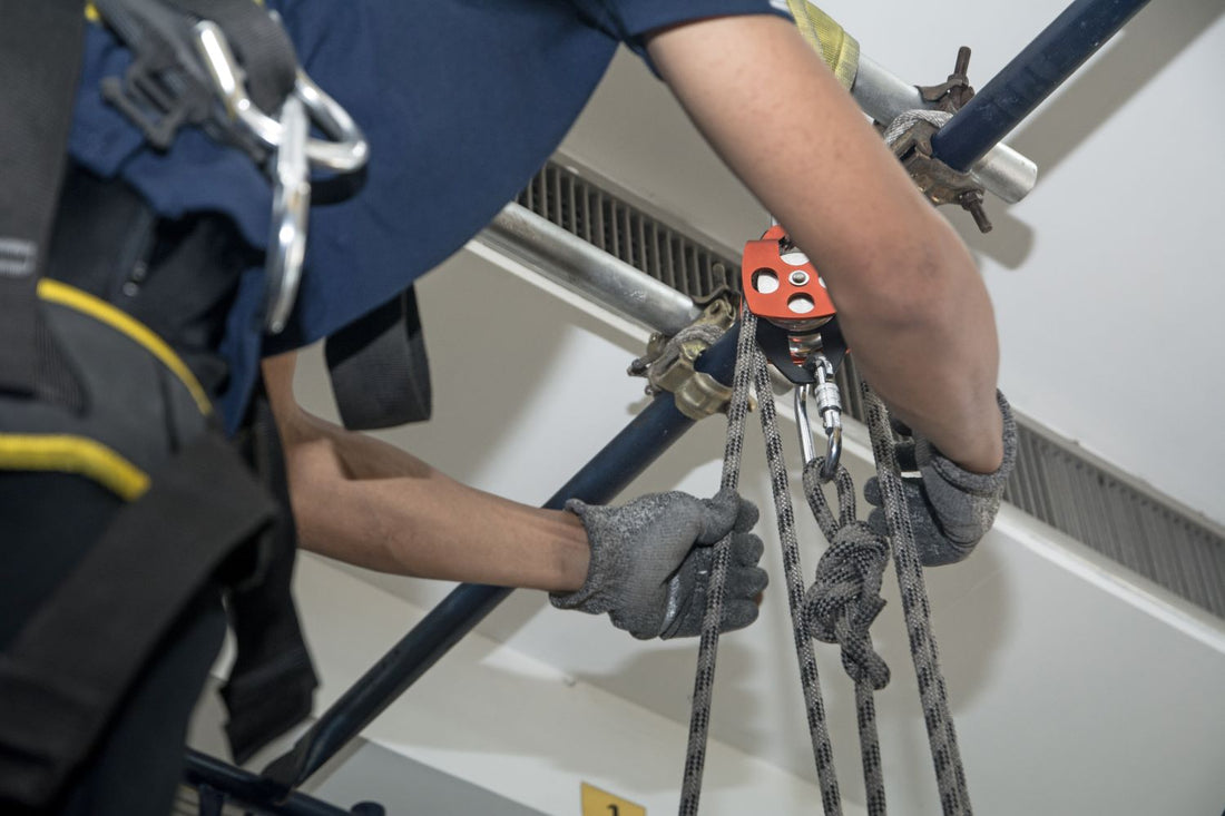 man sets up snatch block with wire ropes
