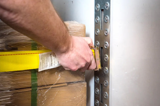 E-Track strap being inserted into vertical E-track in enclosed trailer