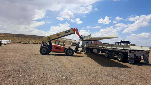large forklift loading cargo onto flatbed truck